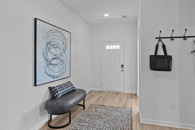 entryway featuring visible vents, baseboards, and wood finished floors