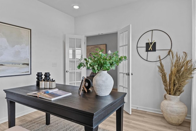 home office with baseboards and light wood-style floors