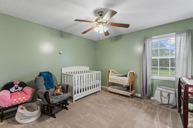 bedroom featuring baseboards, a ceiling fan, carpet flooring, and a textured ceiling