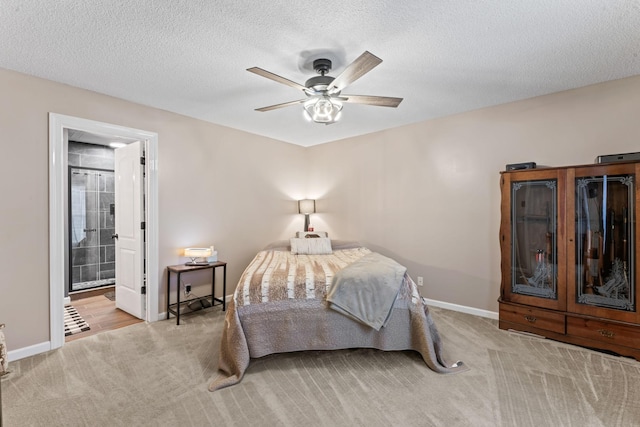 carpeted bedroom featuring baseboards, ensuite bathroom, and a textured ceiling