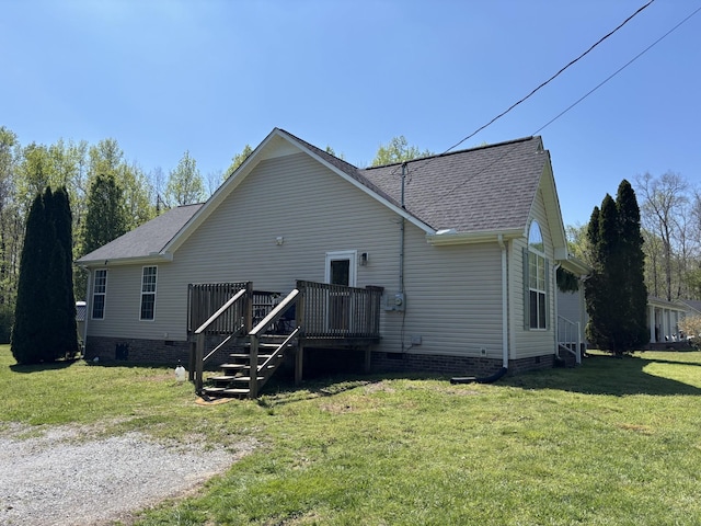 back of house featuring crawl space, roof with shingles, a yard, and a deck