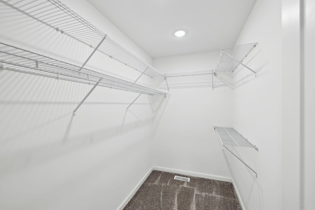 walk in closet featuring visible vents and carpet