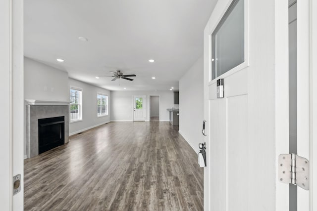 unfurnished living room with wood finished floors, a fireplace, a ceiling fan, and recessed lighting