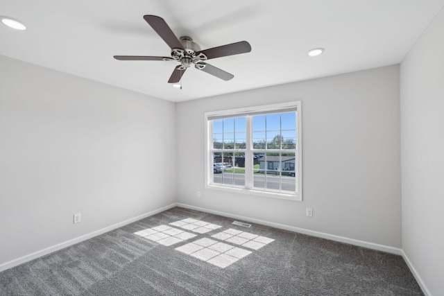 spare room featuring carpet, visible vents, and baseboards