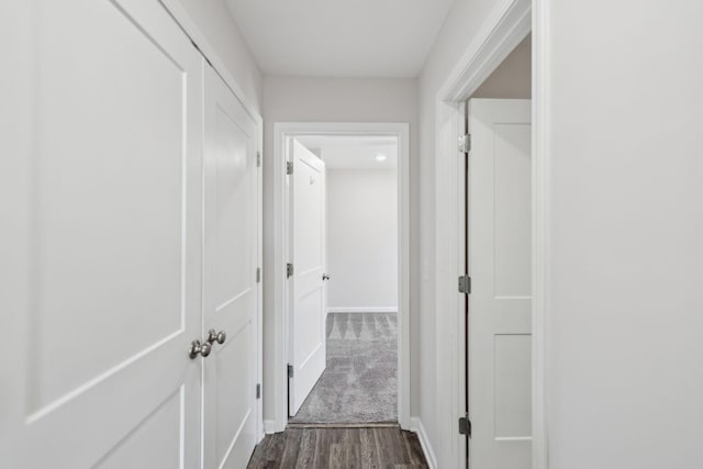 corridor with baseboards and dark wood finished floors