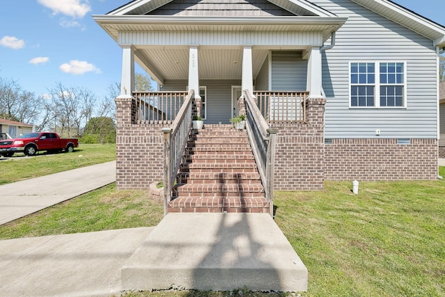 property entrance with a yard and covered porch