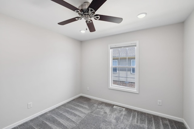 carpeted spare room featuring visible vents, baseboards, and a ceiling fan