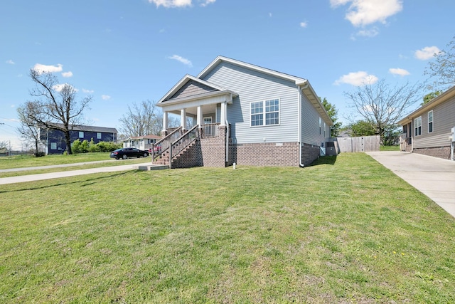 view of front of house featuring stairway, a porch, fence, a front lawn, and concrete driveway