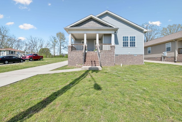 bungalow-style house with a front lawn, covered porch, crawl space, and concrete driveway