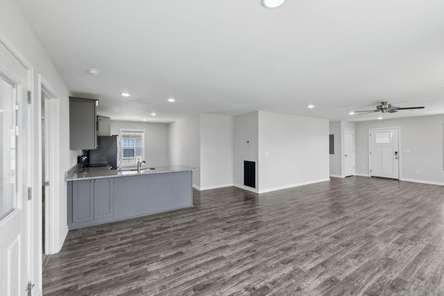 unfurnished living room with dark wood-type flooring, ceiling fan, recessed lighting, and plenty of natural light