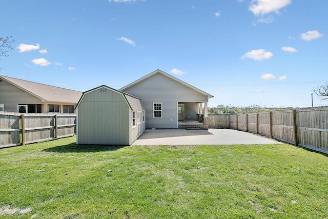 rear view of house with a shed, a patio area, a yard, a fenced backyard, and an outdoor structure