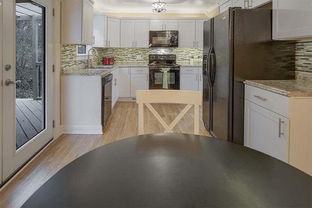 4712 Miners Cv, Antioch, TN 37013 - kitchen with white cabinets, black appliances, decorative backsplash, light wood finished floors, and a sink