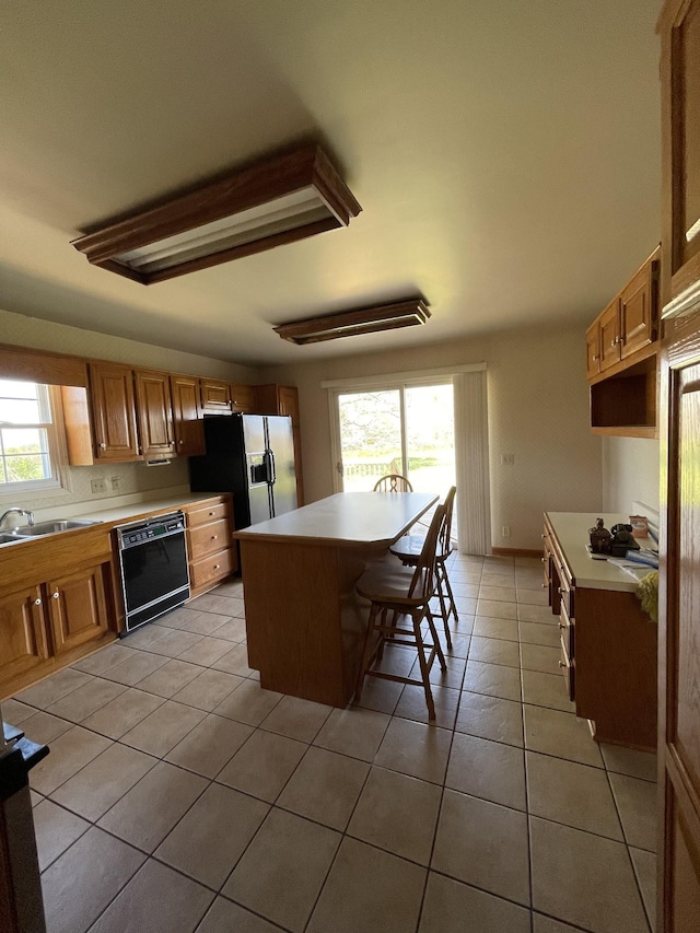 kitchen featuring a sink, fridge with ice dispenser, plenty of natural light, and dishwasher