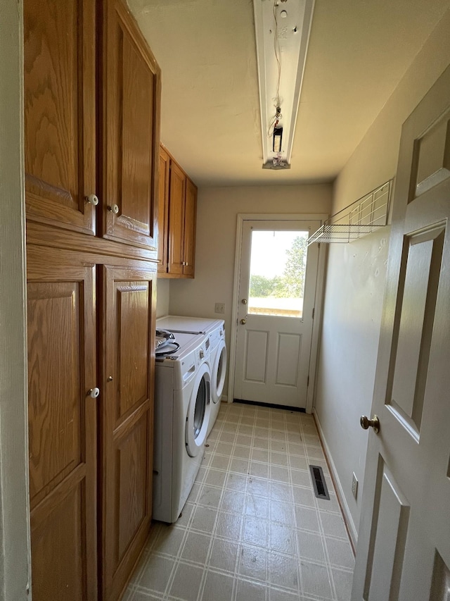 laundry area featuring baseboards, visible vents, independent washer and dryer, cabinet space, and light floors