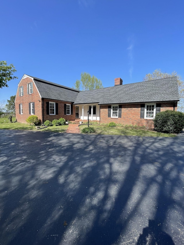 single story home with a chimney and brick siding