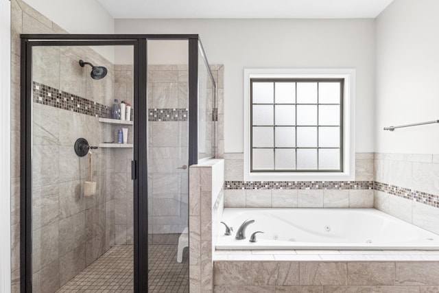 full bathroom featuring a shower stall and a tub with jets