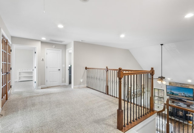 corridor featuring recessed lighting, visible vents, an upstairs landing, baseboards, and light colored carpet