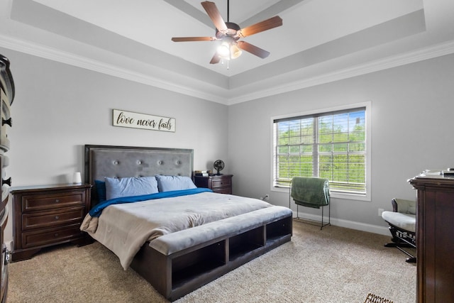 bedroom featuring baseboards, crown molding, a tray ceiling, and carpet
