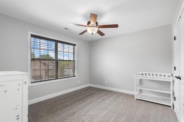 unfurnished bedroom featuring baseboards, a ceiling fan, visible vents, and carpet
