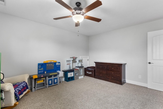 recreation room with baseboards, a ceiling fan, and carpet