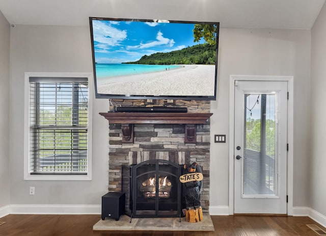 living room with a wealth of natural light, wood finished floors, and visible vents