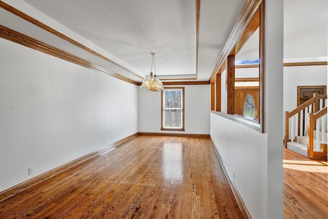 101 Christina Ct, Goodlettsville, TN 37072 - empty room with baseboards, a notable chandelier, a tray ceiling, stairway, and wood finished floors