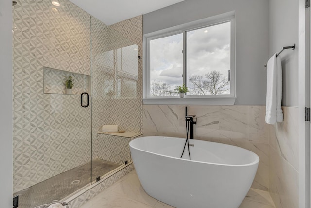 3904 Nevada Ave, Nashville, TN 37209 - full bathroom featuring a freestanding bath, tile walls, a shower stall, a wainscoted wall, and marble finish floor