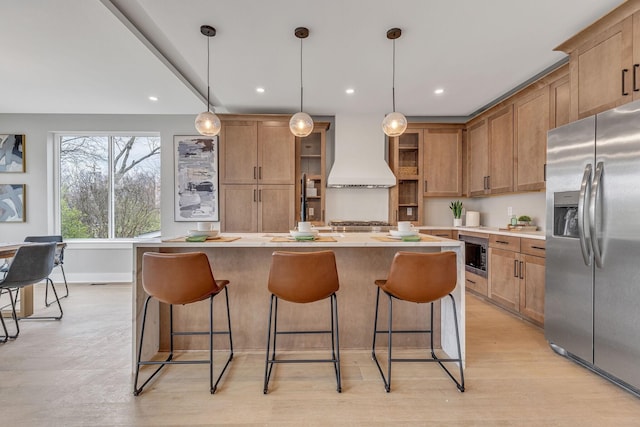 3904 Nevada Ave, Nashville, TN 37209 - kitchen featuring a kitchen breakfast bar, a kitchen island, custom exhaust hood, stainless steel appliances, and brown cabinets