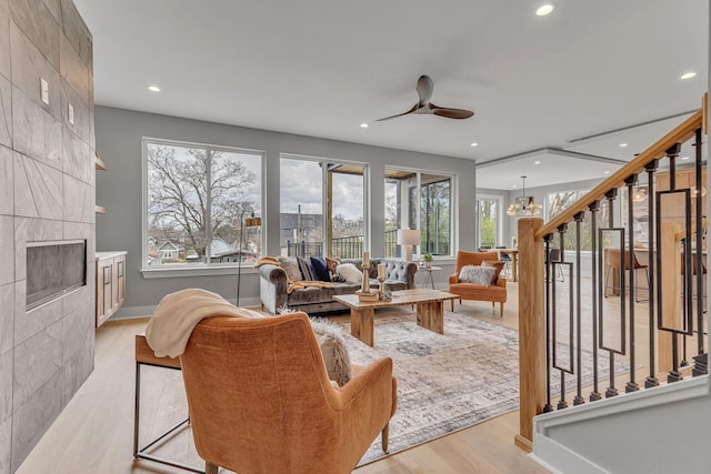 3904 Nevada Ave, Nashville, TN 37209 - living room featuring recessed lighting, light wood-style floors, ceiling fan with notable chandelier, and a healthy amount of sunlight