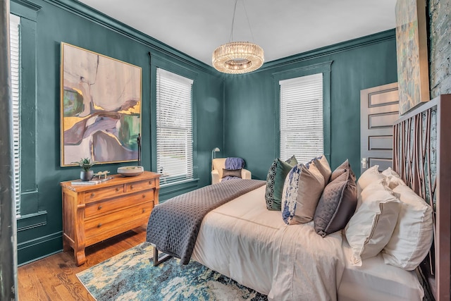 bedroom featuring wood finished floors and crown molding