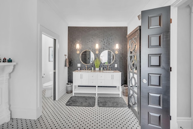 full bath featuring double vanity, toilet, baseboards, and a sink