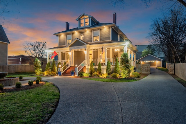 traditional style home featuring covered porch, a chimney, fence, an outbuilding, and driveway