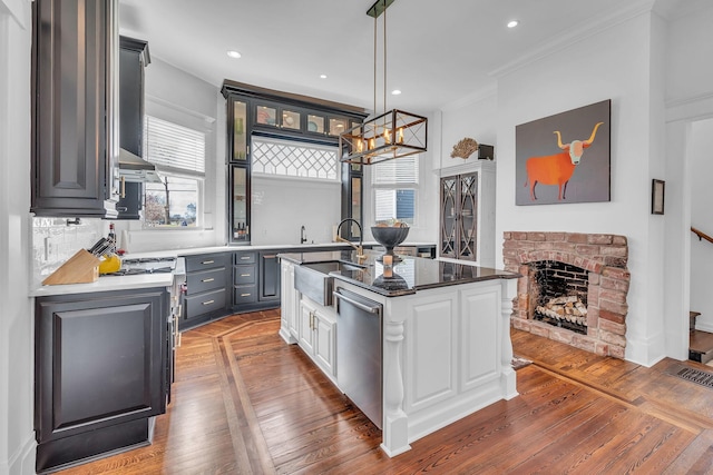 kitchen with a sink, visible vents, a chandelier, glass insert cabinets, and dishwasher