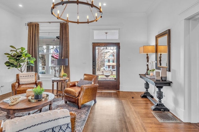 sitting room featuring recessed lighting, wood finished floors, visible vents, crown molding, and a notable chandelier