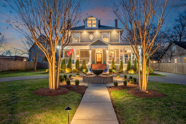 view of front of property with a porch, a front yard, and fence