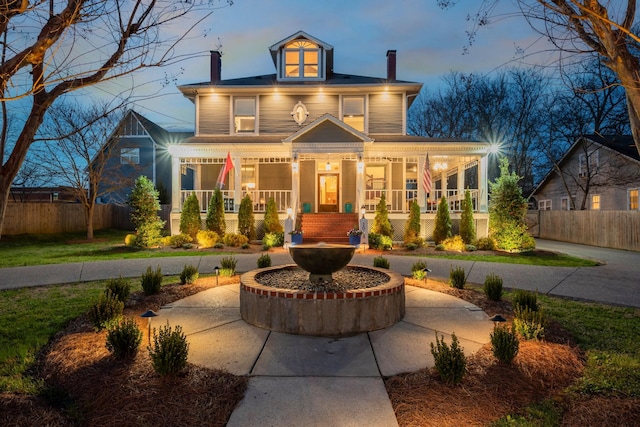 traditional style home featuring fence, a porch, and a chimney