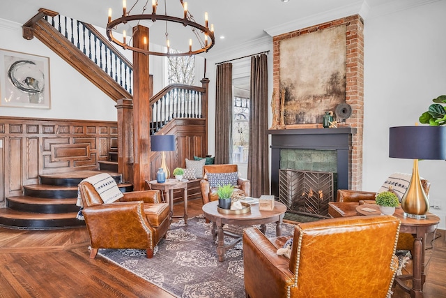 living area featuring stairway, crown molding, wood finished floors, and an inviting chandelier