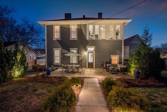 rear view of house with a chimney, fence, a patio, and an outdoor hangout area