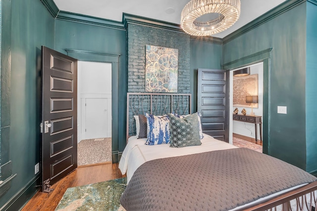 bedroom featuring baseboards, crown molding, and wood finished floors