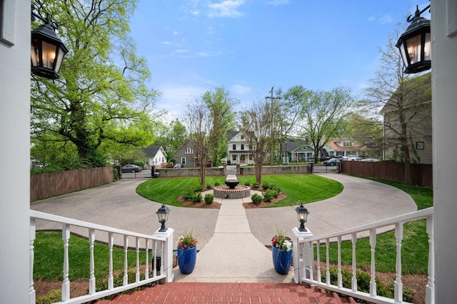 exterior space with a residential view, a lawn, and fence