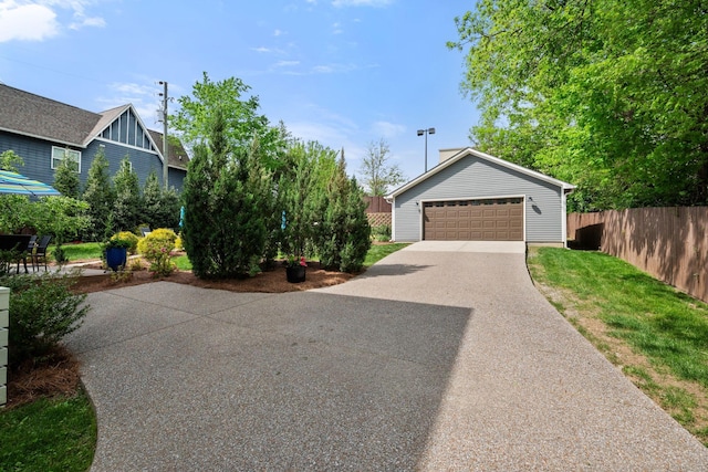 view of front of house featuring fence, an outdoor structure, and a detached garage