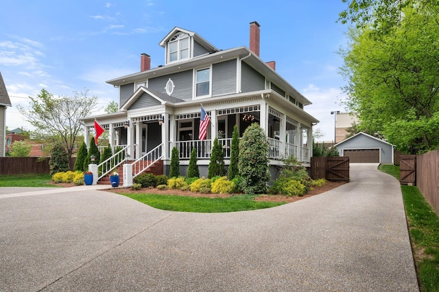 view of front of property with a chimney, fence, an outdoor structure, covered porch, and a detached garage