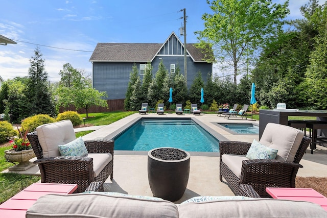 pool with fence, a patio area, and an in ground hot tub