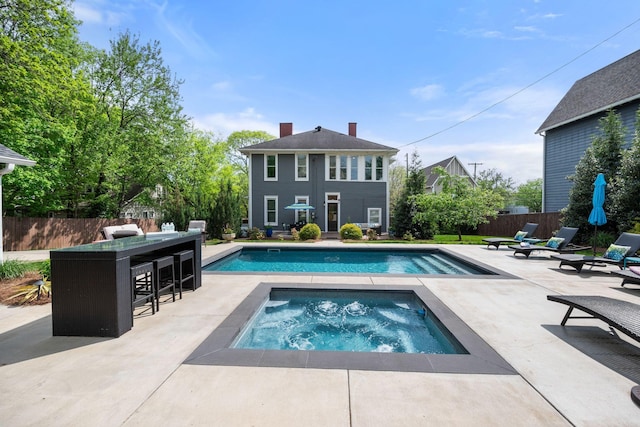view of pool featuring fence, a fenced in pool, outdoor dry bar, and a patio