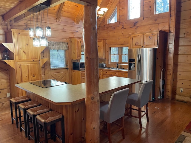 1041 High Meadow Dr, Spencer, TN 38585 - kitchen with wooden walls, beamed ceiling, wood finished floors, and stainless steel appliances