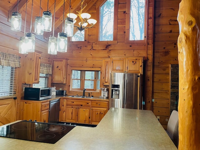 1041 High Meadow Dr, Spencer, TN 38585 - kitchen featuring appliances with stainless steel finishes, wood walls, a sink, and a notable chandelier