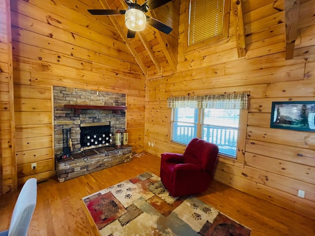 1041 High Meadow Dr, Spencer, TN 38585 - living room with lofted ceiling with beams, a stone fireplace, a ceiling fan, wood finished floors, and wood walls