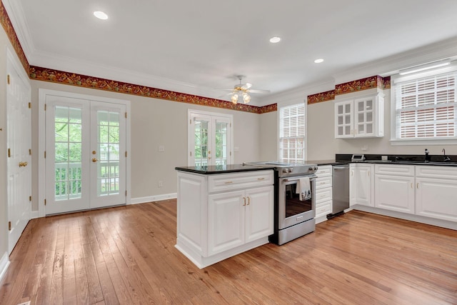 234 Myles Manor Ct, Franklin, TN 37064 - kitchen with light wood-style flooring, stainless steel appliances, dark countertops, a peninsula, and french doors