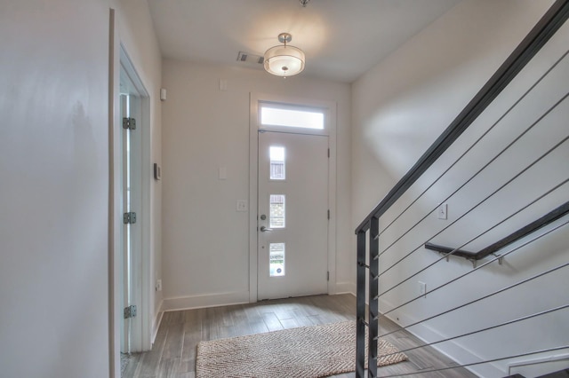 entrance foyer featuring stairs, light wood finished floors, and baseboards
