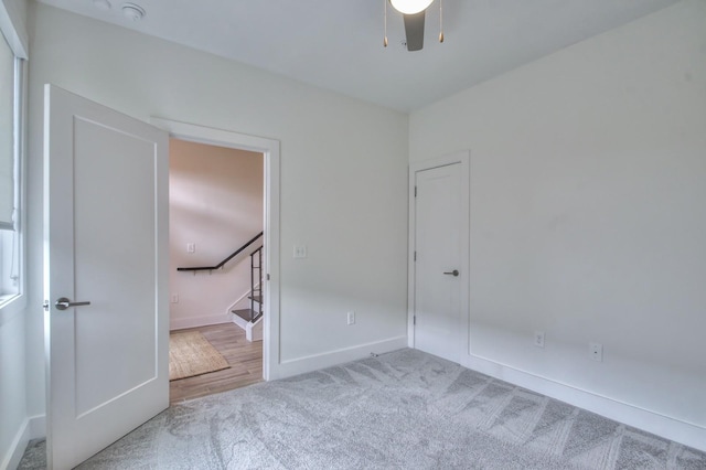 unfurnished bedroom featuring carpet floors, baseboards, and a ceiling fan